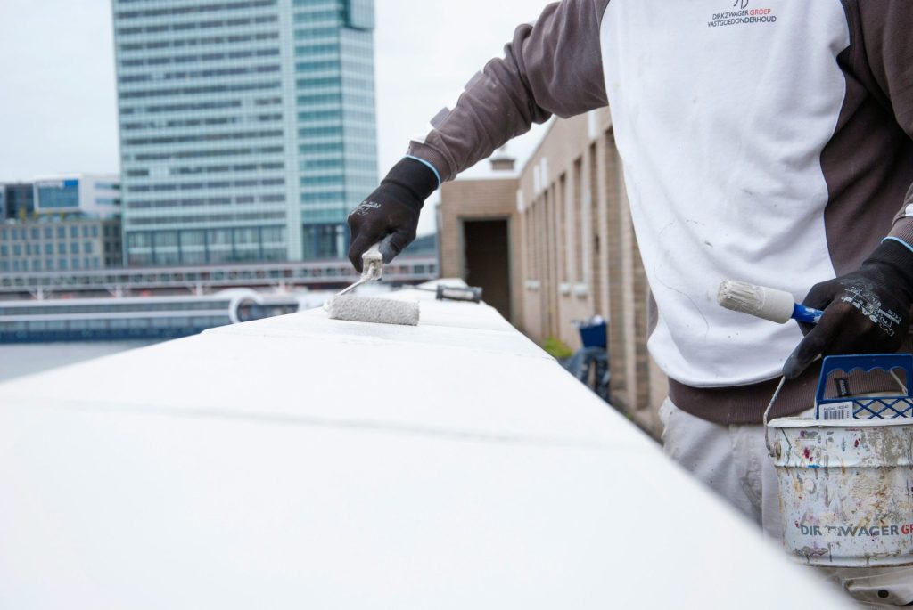 a man painting a wall with a paint roller