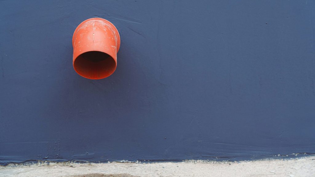 Orange pipe and blue wall.